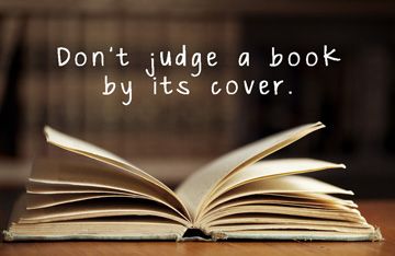 An open book with the phrase Don't Judge a Book By Its Cover in white text.